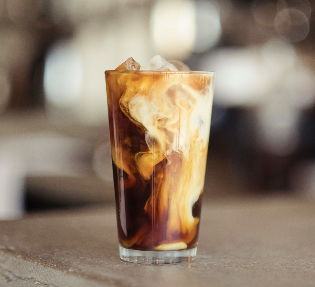 Glas mit Eiskaffee und Milch