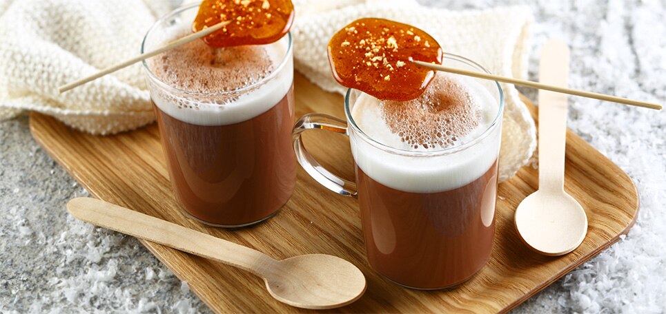 Zwei Gläser Cappuccino Ice Cocktail, drappiert mit exotischen Früchten