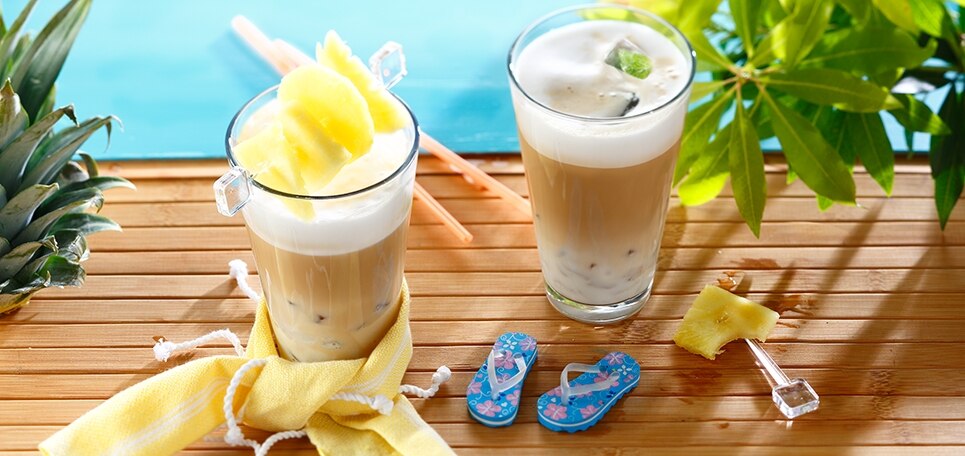 Zwei Gläser Cappuccino Ice Cocktail, drappiert mit exotischen Früchten